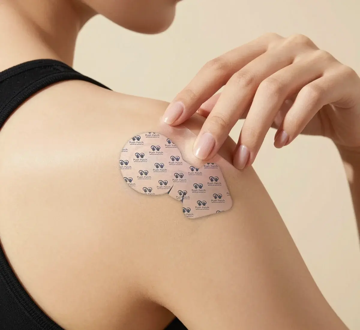 A hand pressing a clear Push Patch onto a shoulder